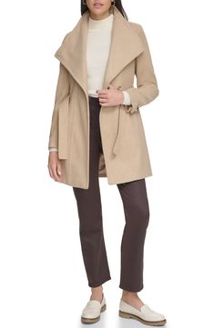 Keep out the cold in this stylish coat framed with a wing collar and defined with a waist tie belt. Wing collar Toggle cuffs Removable tie belt Lined Nickel and camel are 64% polyester, 18% acrylic, 18% rayon; black and white is 51% wool, 45% polyester, 2% nylon, 2% rayon; oatmeal twill is 58% wool, 31% polyester, 6% acrylic, 4% nylon, 1% rayon; black herringbone is 66% polyester, 20% acrylic, 14% rayon Dry clean Imported Model stats: 5'10" height, 32" bust, 25" waist, 36" hip. Model is wearing Fitted Beige Winter Outerwear, Fitted Pea Coat For Fall, Fitted Wool Coat For Cold Fall Weather, Fitted Long Coat For Fall, Calvin Klein Long Sleeve Outerwear For Fall, Calvin Klein Winter Outerwear For Work, Calvin Klein Outerwear For Fall Cold Weather, Calvin Klein Fall Outerwear For Cold Weather, Fitted Hooded Pea Coat For Fall