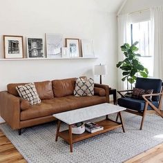 a living room filled with furniture and pictures on the wall