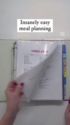 a person is holding a piece of paper in front of a binder with the words insannely easy meal planning on it