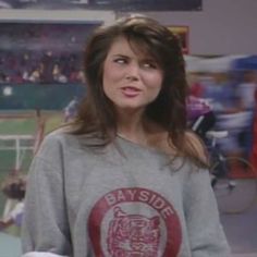 a woman standing in front of a tv screen wearing a bay side tiger t - shirt