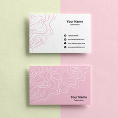 two business cards sitting next to each other on top of a pink and green surface