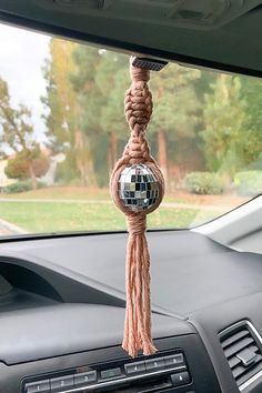 a car dashboard with a mirror ball hanging from it's center console, and a rope attached to the dash board