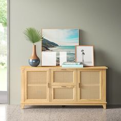 a wooden cabinet with pictures and plants on top