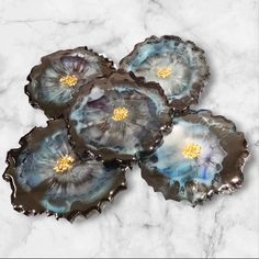 three blue agate glass dishes sitting on top of a marble counter