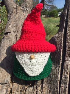 a crocheted gnome hat hanging on a tree