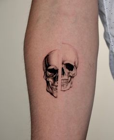 a man's arm with a skull tattoo on it