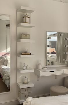 a bedroom with a bed, mirror and dressing table in the corner next to it