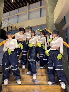 the models are dressed in blue and white outfits with green gloves on their heads, while standing on some stairs