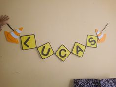 a child's room with yellow and black letters hanging from the wall next to a bed