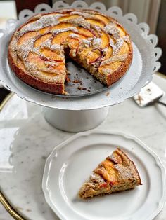 a cake sitting on top of a white plate next to a slice of pie and fork