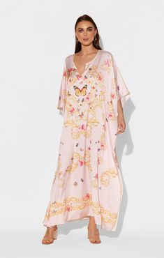 Gold, ornate filigree make a lovely resting place for a kaleidoscope of Butterflies and flowers in this blush pink long caftan. The flowing silhouette is constructed from our signature Polysilk fabric, reminiscent of the delicate movement a butterflies' wings take in flight. This long, floral caftan is suitable for everyday loungewear, dress-up, or something incredibly comfortable to sleep in. Printed long caftan Lusciously soft poly silk Lightweight and breathable Machine washable for easy care Elegant Pink V-neck Kaftan, Elegant Floral Print Flowy Kaftan, Elegant Silk Floral Print Kaftan, Feminine Silk Maxi Dress For Beach, Pink Kaftan With Floral Print And Kimono Sleeves, Pink Silk Kaftan For Vacation, Silk Maxi-length Spring Kaftan, Silk Maxi Length Kaftan For Spring, Silk V-neck Spring Kaftan