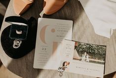 the wedding stationery is laid out on the table with shoes, ring and jewelry