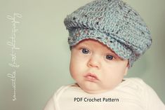 a baby wearing a crochet hat looking at the camera