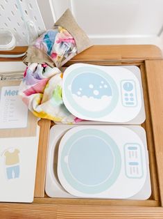 a wooden table topped with plates and bowls next to a basket filled with cloths