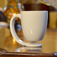 a white coffee cup sitting on top of a wooden table