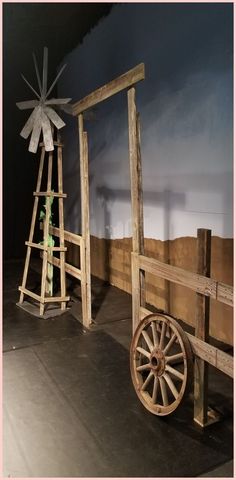 an old wagon and windmill on display in a museum