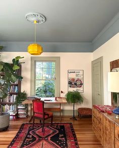 a living room filled with furniture and a large rug on top of a hard wood floor