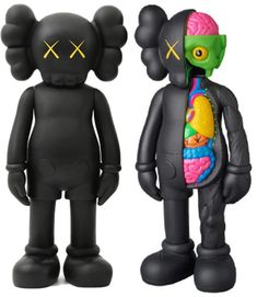 two black toy figures with different colored parts on their faces and torsos, one in the shape of a human body