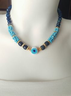 This lapis necklace made of lapis natural stone and handmade glass evil eye beads.  These elegant lapis and glass beaded necklace can be a very good choice as gifts to yourself and loved ones when approaching the holiday.  The glass beads in this necklace are made entirely of handmade glass in traditional ovens.  This lapis necklace is 17.70 inches lenght.  This lapis natural stone necklace is wonderful gift to yourself or to your loved one.The minimalist necklace is totally handmade,in a smoke Blue Evil Eye Jewelry For Meditation, Lapis Lazuli Gemstone Beads For Jewelry Making, Bohemian Blue Beaded Necklaces With Evil Eye, Handmade Blue Crystal Necklace - Spiritual, Handmade Spiritual Lapis Lazuli Crystal Necklace, Handmade Blue Crystal Spiritual Necklace, Handmade Blue Spiritual Crystal Necklace, Handmade Spiritual Blue Crystal Necklace, Blue Czech Glass Spiritual Necklace