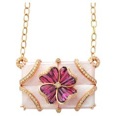 14K gold pink mother of pearl rhodolite special cut flower pendant necklace Elevate your elegance with our exquisite pendant crafted in 14 karat gold. The focal point is a stunning arrangement of four rectangular Pink Mother of Pearl pieces seamlessly joined into a single rectangle, creating a mesmerizing backdrop. At the heart of this masterpiece lies a delicate flower motif, formed by tapered baguette rhodolites channel-set into a four-petal design. Sparkling diamonds adorn the surface of both Exquisite Gemstone Flower Pendant Necklace, Elegant Pink Gold Necklace With Flower Pendant, Elegant Pink Gold Flower Pendant Necklace, Exquisite Pink Gemstone Necklaces, Exquisite Pink Gemstone Necklace, Luxury Pink Gold Gemstone Necklaces, Elegant Flower-shaped Mother Of Pearl Necklace, Luxury Pink Necklace With Pearl Pendant, Exquisite Pink Pendant Necklace