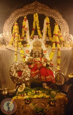 an idol with flowers and garlands around it