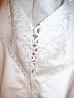 the back of a wedding dress with beading on it