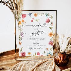 the wedding stationery is decorated with flowers and feathers