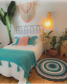 a bedroom with a bed, rug and potted plants on the side of the room