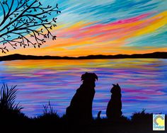 two dogs sitting next to each other in front of a tree and water at sunset