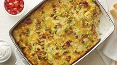 a casserole dish with meat and vegetables in it on a white tablecloth