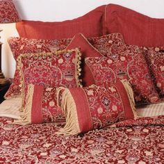 a bed with red and gold bedspread and pillows