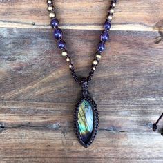 A stunning piece of labradorite, it has a very reflective rainbow of colors in this piece which I love! Wrapped in dark brown macrame cord, threaded on a beaded necklace featuring high quality amethyst round beads and brass beads.  adjustable length. Tear drop shape pendant, height 4.2cm x 2cm width This piece is beautiful, my favourite part is the purple color that roses from the base of the pendant, and this is what I have drawn on and incorporated into the necklace, by adding the beautiful pu Handmade Brown Labradorite Necklace, Bohemian Beaded Labradorite Crystal Necklaces, Bohemian Labradorite Beaded Crystal Necklaces, Bohemian Labradorite Beaded Crystal Necklace, Brown Macrame, Crystal Necklaces, Sliding Knot, Macrame Necklace, Macrame Cord