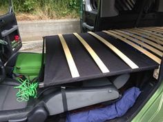 there is a bed in the back of a green truck with wood slats on it