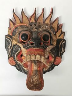 a wooden mask hanging on the wall