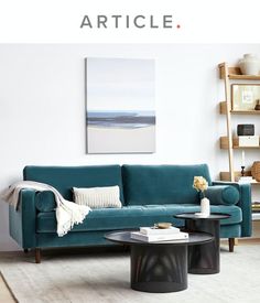 a living room with a blue couch and coffee table in front of a white wall