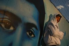 a man standing in front of a wall with a painting on it's side