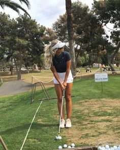 a woman is playing golf on the grass