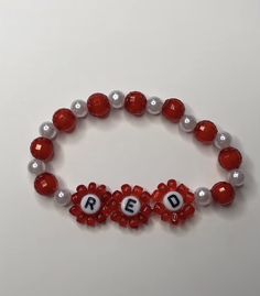 a red and white beaded bracelet with letters