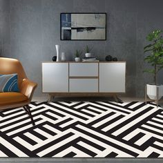 a black and white rug in a living room with a chair, sideboard and potted plant