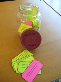 a jar full of sticky notes sitting on top of a wooden table