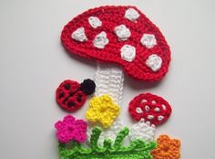 crocheted mushrooms and flowers on a white surface