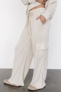 Relax in style with our Portland Knit Cargo Pants in Natural. These soft and stylish cargo pants include two sets of functional pockets, plus an elastic drawstring waistband. They're the perfect blend of style and ease for lounging. Beige Relaxed Fit Sweatpants With Pockets, Beige Wide Leg Sweatpants With Side Pockets, Relaxed Fit Beige Sweatpants With Pockets, Utility Cargo Pants For Loungewear, Beige Drawstring Bottoms For Loungewear, Casual Neutral Pants With Side Pockets, Beige Lounge Bottoms With Pockets, Beige Bottoms With Pockets For Loungewear, Versatile Cargo Loungewear Pants