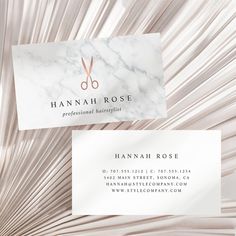 two business cards with scissors on them in front of a white and gray background that is made out of paper