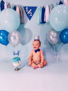 a baby is sitting in front of some balloons