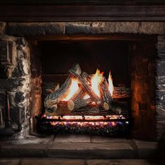 a fire burning in a fireplace with logs