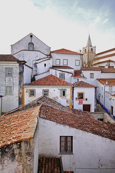 there are many white buildings with red roofs