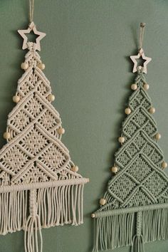 two crocheted christmas trees hanging on the wall next to each other with wooden beads