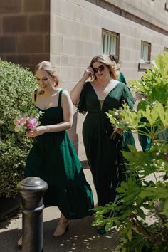 two women in green dresses walking down the street