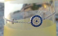 Silver bracelet with Cubic Zirconia a sideways cross and an astonishing circle evil eye with blue and clear Cubic Zirconia. It is made with high quality, 925 sterling silver chain. Elegant&dainty, catching gently everyone's attention. Appropriate either for everyday or formal looks. Also available in 14k gold filled. Have a look at the following link for more perfect combinations: https://www.etsy.com/listing/873929293 Length approx. 6.2 inches / 16cm - can be adjusted upon request. ♥ All it Sterling Silver Evil Eye Bracelet, Silver Evil Eye Bracelet, Adjustable Silver Bracelet, Round Evil Eye, Bracelet Evil Eye, Christian Bracelets, Gift Envelope, Cross Bracelet, Circle Of Life