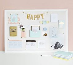 a white board with gold foil lettering on it that says happy and is surrounded by other office supplies